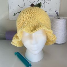 Introducing the Crochet Lemon Bucket Hat! This zesty accessory brings a burst of citrusy freshness to your style. Meticulously crafted with bright yellow yarn and adorned with cute lemon slices, it's a playful and vibrant addition to your wardrobe. Whether you're soaking up the sun or adding a pop of color to your outfit, this crochet lemon bucket hat is the perfect blend of fashion and fun. Embrace the sunny vibes and stand out with this delightful and handmade hat! Crochet Lemon, Yellow Yarn, Sunny Vibes, Lemon Slices, Lemon Slice, Handmade Hat, Bucket Hats, Bright Yellow, Bucket Hat