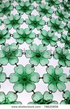 green glass flowers are arranged in the shape of an abstract pattern on a white background