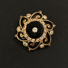 "Gold, black and clear glass is a classic combination, brought together to excellent effect in this small and lovely mourning brooch. The black of the onyx is echoed in the black enamel accentuating the gold. This design was copied by Coro in the mid century, but this brooch is the real thing, as indicated by the pin which extends 1/8\" beyond the clasp, where more modern pins do not. Circa 1900-1910, or perhaps a little later, which would make it Edwardian. The piece is extremely well made and solidly constructed. All parts are intact. Measures 1 3/8\" in diameter. In excellent condition." Sweet Notes, Antique Victorian, Black Enamel, Clear Crystal, Gold Black, The Black, Clear Glass, Onyx, Bangles