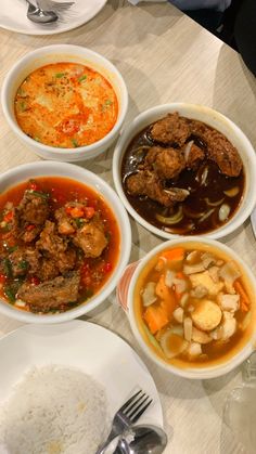 four bowls of food are sitting on a table