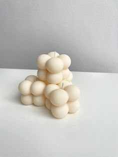 a bunch of white balls sitting on top of a table next to a candle holder