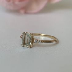 a close up of a ring with a flower in the background