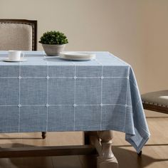 a blue table cloth with white squares on it and two plates sitting on the table