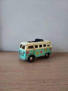 a toy van is sitting on a wooden floor next to a white wall and door