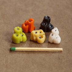 four different colored candies sitting on top of a table next to a pencil and eraser