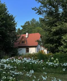 a white house surrounded by trees and flowers