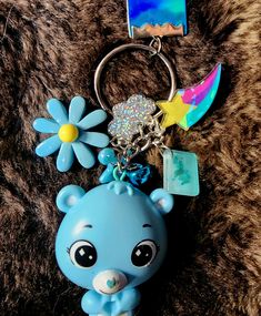 a little blue bear keychain with a flower on it's head and a star