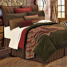 a bed covered in blankets and pillows next to a window with a stone wall behind it