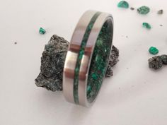 Wedding ring, Marriage, Engagement, special and unique gift. Beautiful combination of dark green Emerald with Malachite green stone. Beautiful mosaic of natural stones. The photo ring is 6mm width. The metal color of this ring is silver. Stone and wood are my favorite materials for making rings. These two natural elements give to the jewels the unique character of a piece manufactured by hand. The process for manufacturing this titanium band ring with Dark Emerald and Malachite stone reconstitut Nontraditional Mens Wedding Rings, Green Male Wedding Ring, Modern Green Round Band Jewelry, Modern Green Stainless Steel Jewelry, Green Jewelry With Round Band For Gift, Green Round Band Jewelry Gift, Modern Green Jewelry For Promise Occasion, Green Stainless Steel Ring As A Gift, Green Stainless Steel Ring For Gift