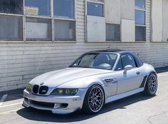 a silver sports car parked in front of a building