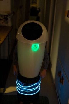 a person standing in a kitchen with a light up trash can on their back legs