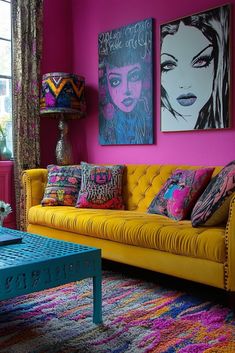 a living room with pink walls and yellow couches in front of paintings on the wall