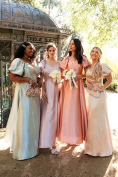 four bridesmaids pose for a photo in front of the gazebo