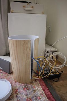 a large wooden vase sitting on top of a rug next to a white refrigerator freezer