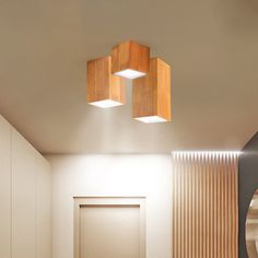 two square wooden lights hanging from the ceiling in a room with white walls and wood paneling