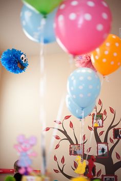 balloons are floating in the air near a tree