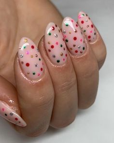 For a joyful holiday vibe, these nails sparkle with rainbow polka dots against a soft pink base. Metallic green, red, and gold dots are mixed with silver glitter accents, creating a playful, confetti-like effect. This nail art design is lively and captures the spirit of the holiday season, making it a fantastic choice for those who love a splash of color and a bit of festive flair. Festive Nails Christmas, Christmas Nails Glitter, Beginner Nail Designs, Polka Dot Christmas, Christmas Nail Ideas, Dot Nail Designs, Dot Nails, Red Nails Glitter, Glitter Accent Nails