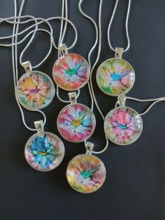 four necklaces with different designs on them