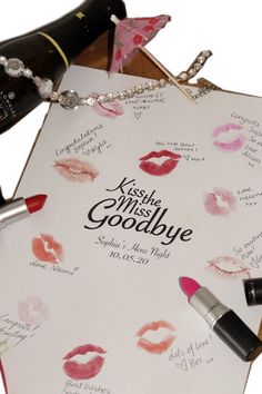 lipstick and wine bottles on top of a piece of paper that says kiss me goodbye