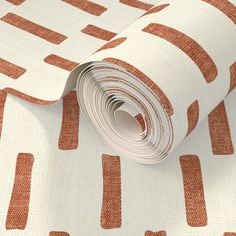 an orange and white wallpaper with red squares on the bottom, along with a roll of tape