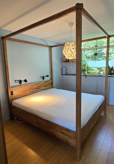 a four poster bed in a bedroom with hardwood floors