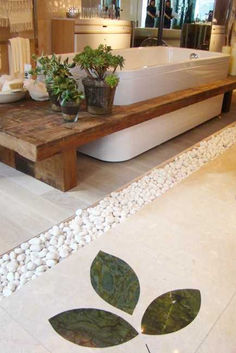 a bath tub sitting on top of a white tiled floor next to a wooden table