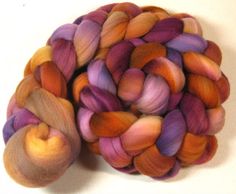 two skeins of dyed wool sitting next to each other on a white surface