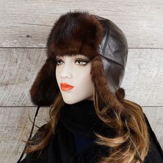 Real brown mink fur aviator hat, brown leather, Charles model, for women. Unisex. This hat will go perfectly with those wanting to combine beauty and practicality. Mink fur adds a touch of classic and sophistication to this accessory. This chapka can be worn in three ways using the drawstrings:1. Attached under the chin for colder days.2. Tied up, for warmer days.3. Tied towards the back, your ears and neck are covered while having the earflaps raised. Very practical! So, ideal depending on the temperature or the desired style. Warmer than the competition, this model has earflaps long enough to protect the cheeks and neck against the cold and wind. In addition, the interior is lined with a very soft, non-irritating black woolen fabric, which will keep you warmer than a usual quilted lining Luxury Brown Hat For Fall, Brown Sheepskin Hat With Faux Fur Lining, Brown Hat With Faux Fur Lining And Ear Flaps, Brown Hats With Faux Fur Lining And Ear Flaps, Adjustable Brown Hats With Faux Fur Lining, Brown Leather Hats With Faux Fur Lining, Brown Aviator Winter Hats, Winter Brown Aviator Hats, Brown Winter Hats