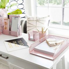 pink and gold office supplies on a white desk