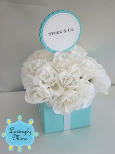 there is a blue box with white flowers in it and a sign that says stork & co