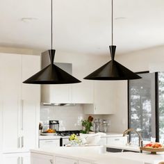 two black lights hanging over a kitchen island