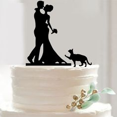 a wedding cake topper with a silhouette of a couple and their dog