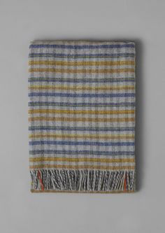 a multicolored plaid blanket with fringes