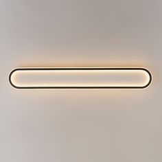 a modern bathroom light with dim lighting on the wall and below it is a rectangular tube