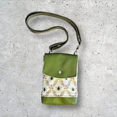 This minimalist crossbody is perfectly compact and is as well suited for a day of errands as it is for travelling.  Beneath a flap that snaps closed you will find the main slip compartment, which keeps essentials like phones, mid-sized wallets, earbuds, and keys handy, as well as a slimmer slip pocket.  The slimmer slip pocket under the flap and the back slip pocket are both ideal for thinner items like card wallets, lip balm, and more.  This features an adjustable crossbody strap which is also Green Crossbody Phone Bag With Adjustable Strap, Green Rectangular Phone Bag With Detachable Strap, Green Phone Bag With Detachable Strap For Travel, Green Phone Bag With Adjustable Strap For Travel, Green Crossbody Shoulder Bag With Cell Phone Pocket, Green Phone Bag As Gift, Square Phone Bag With Removable Pouch For Travel, Green Square Phone Bag With Adjustable Strap, Green Crossbody Phone Bag For Travel