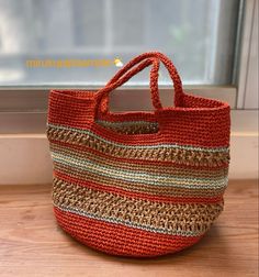 an orange bag sitting on top of a wooden floor next to a window sill