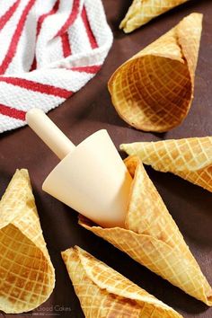 some cones are sitting on a table next to a red and white striped dish towel