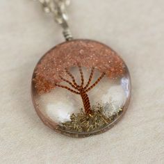 What a truly special piece the Sephira Life Tree Pendant Necklace is! A beautiful, blooming tree of life design is embedded into clear resin, which hangs as a pendant from a silver-toned chain. Makes a perfect gift for a beloved grandparent or family member, symbolizing ancestral roots. Lovingly handcrafted by artisans with Intercrafts Peru, a cooperative with more than 700 makers who come together to strengthen communities by providing access to health care, loans, advances, and training while Spiritual Silver Necklace With Natural Inclusions, Nickel-free Silver Resin Jewelry, Nature-inspired Tree Of Life Round Jewelry, Nature-inspired Round Pendant Jewelry Gift, Nature-inspired Hypoallergenic Jewelry For Gifts, Tree Of Life Pendant Necklace As Gift, Unique Tree Of Life Round Jewelry, Unique Tree Of Life Round Pendant Jewelry, Spiritual Resin Necklace For Gift