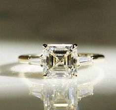 an emerald cut diamond ring with three baguets