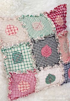 a patchwork pillow made from old pieces of cloth and fabric with hearts on it