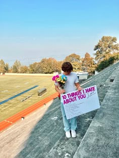 a woman holding flowers and a sign that says 10 things i hate about you on it