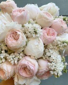 a bouquet of pink and white flowers in someone's hand