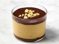 a dessert in a glass with chocolate and nuts on the top, ready to be eaten