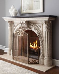 an ornate fireplace in a living room with a painting on the wall and a rug