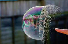 a person is holding a soap bubble in their hand