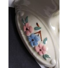 a ceramic dish with flowers painted on it's side, sitting on a table