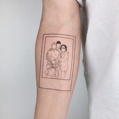 a man's arm with a drawing of two people holding each other on it