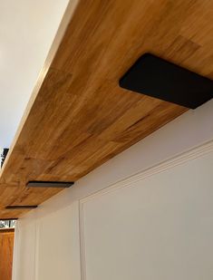 the ceiling is made from wood and has black metal brackets on it's sides