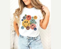 Retro Smiley Faces Shirt, Smile Face T-Shirt, Vintage Smiley Face Shirt, Trendy Shirts for Women Youth Kids Toddler Baby,Smiling Emoji Shirt Thank you so much for choosing us! How To Order 1️⃣ Please review all the information provided before placing an order. 2️⃣ Select the shirt type and size using the drop down menu. 3️⃣ Select the color of the shirt using the following drop down menu. 4️⃣ Once all your desired items are in your cart you may complete your order by entering your payment method Casual Multicolor Tops With Funny Print, Casual Multicolor Top With Funny Print, Playful White T-shirt With Smiley Face, Fun Cotton T-shirt With Smiley Face, Funny White Short Sleeve Top, Fun White Tops With Cartoon Print, Fun White Top With Cartoon Print, Trendy Multicolor Cartoon Print Shirt, White Fun Tops With Cartoon Print