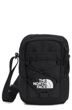 the north face cross body bag in black with white logo on front and shoulder strap